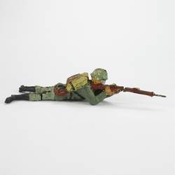 Soldat liegend, mit Gewehr schießend