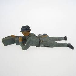 Soldat liegend, mit Munitionskästen