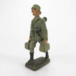 Lineol Soldat marschierend, Ersatzrohr tragend